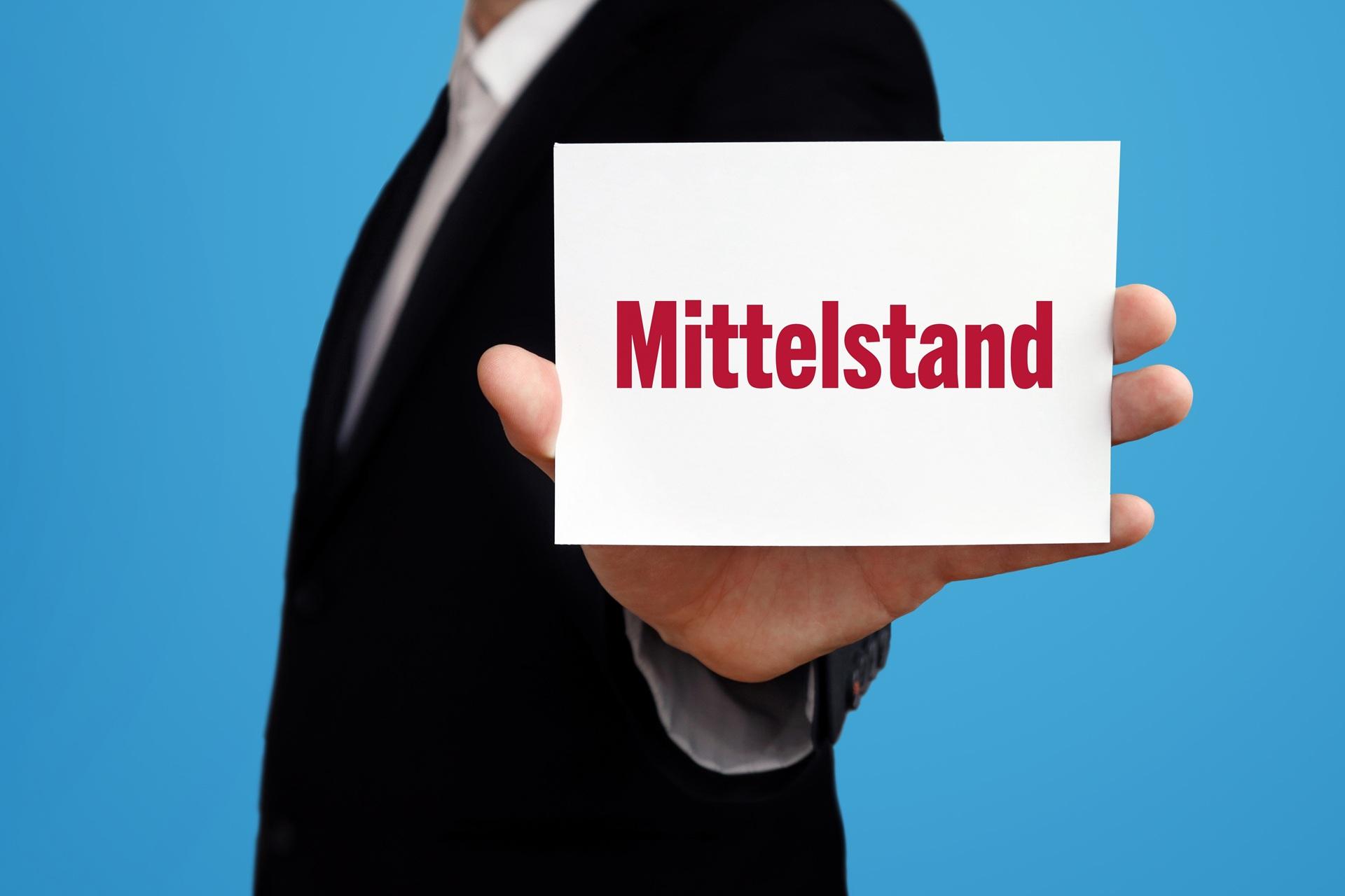 Geschäftsmann hält Schild mit dem Wort Mittelstand | Kaltasphalt